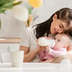 Mama karmi niemowlaka z butelki. Uważaj na przekarmienie niemowlaka mlekiem modyfikowanym objawy, by uniknąć problemów.