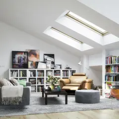 Gemütliche dachgeschosswohnung einrichten mit bequemen Sesseln, Bücherregalen und viel Licht durch Dachfenster.