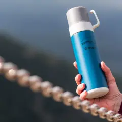 Niebieski termos w góry, idealny towarzysz każdej wyprawy. Z napisem "Mountains are calling" i logo Hi-Tec.