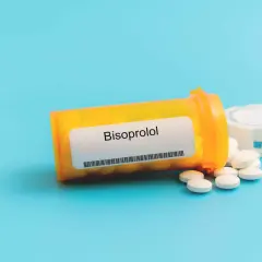 Eine Flasche mit Bisoprolol 2,5 mg Tabletten liegt auf blauem Hintergrund.