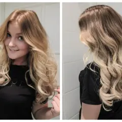 En kvinna med vackra, blonda lockar som ramar in hennes ansikte. Håret är stylat i mjuka vågor.