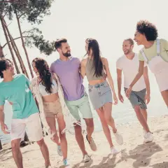 Glatt gäng på stranden, redo för en tipspromenad med frågor för en 30-årsfest. Sol, sand och skratt!