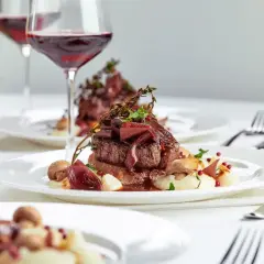 Eleganckie danie z wołowiny z puree i grzybami, podane z czerwonym winem. Zastanawiasz się, ile za talerzyk na wesele?