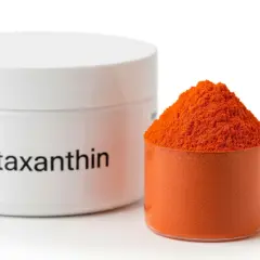 Słoiczek z napisem "Astaxanthin" i miarka wypełniona pomarańczowym proszkiem. Poznaj astaksantyna właściwości!
