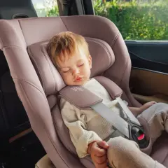 Schlafendes Kleinkind in einer rosafarbenen Babyschale. Die Frage "ab wann sitzschale bei kindern" wird hier durch das Bild beantwortet: ab Geburt.