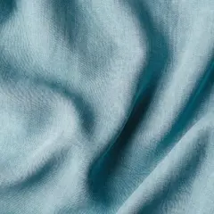 Plissé de textiles artificiels bleu pâle, évoquant la douceur et la fluidité d'une étoffe moderne.
