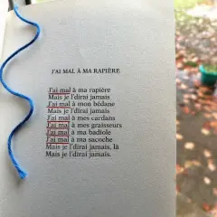 Un poème avec une figure de style répétition en début de phrase : "J'ai mal à ma rapière". Un fil bleu sert de marque-page.