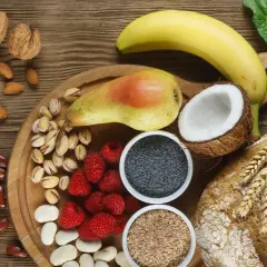 Frutta, noci, semi, legumi e pane integrale: un'abbondanza di cibi ricchi di fibre per una dieta sana.