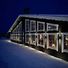 Reftele Wärdshus lyser upp den snöiga kvällen. Varma fönster ger en inblick i en mysig atmosfär.