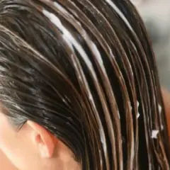 Cabello castaño con tratamiento blanco, mostrando para que sirve el serum para el pelo: hidratación y brillo.
