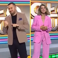 Iza Krzan w Kole Fortuny w różowym garniturze, obok niej prowadzący w eleganckich strojach.
