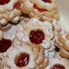 Stos ciastek maślanych z dżemem, oprószonych cukrem pudrem. Idealne na popołudniową herbatę.