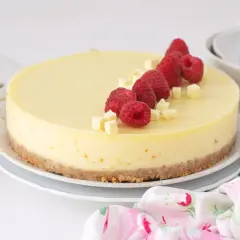 Deliciosa tarta de chocolate blanco, decorada con frambuesas frescas y trocitos de chocolate. ¡Un postre irresistible!