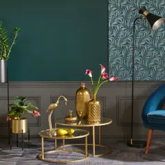 Elegancki salon z turkusowym fotelem i złotymi akcentami. Co to znaczy golden? To blask wazonów, figurki żurawia i ozdobnych luster.