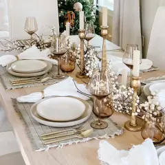 Elegant Christmas tablescapes featuring gold accents, white berry branches, and amber glassware.