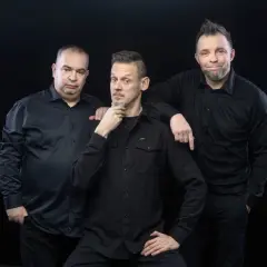 Trzech mężczyzn w czarnych koszulach, tworzących kabaret Ani Mru-Mru.