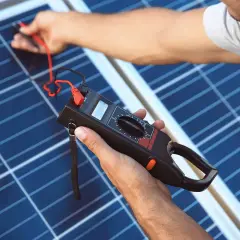 Technik sprawdza panel słoneczny miernikiem. To kluczowe dla działania falownika, który zamienia prąd stały na zmienny.