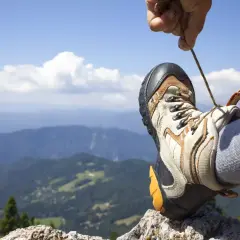 Gotowe do wędrówki! Sznurowanie butów na tle górskiego krajobrazu.