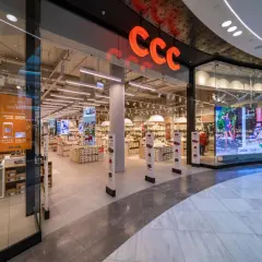 Wejście do sklepu CCC z widocznym logo, półkami z butami i ekranem LED.