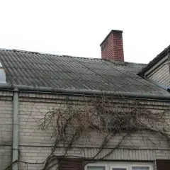Dach pokryty eternitem, który zawiera azbest. Co to za materiał? Widać też komin i antenę satelitarną.