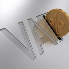 Złota moneta z symbolem procentu wpada do litery "A" w napisie "VAT".
