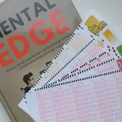 Książka "Mental Edge" i kilka kuponów Lotto ułożonych na białym tle.