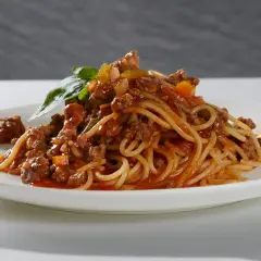 Ein Teller Spaghetti Bolognese, liebevoll zubereitet, mit frischem Basilikum garniert. Perfekt, um bolognese selber machen zu lernen.