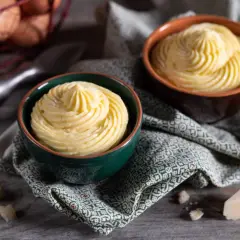 Due ciotole con crema pasticcera salata, guarnita a spirale. In sottofondo uova e formaggio.