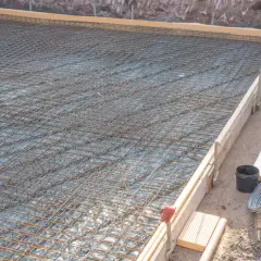 Bewehrung für eine Bodenplatte, vorbereitet in einer einseitige schalung. Stahlmatten liegen bereit für den Beton.