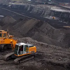 Praca na kopalni węgla brunatnego Turów. Koparki pracują w głębokim wyrobisku, wydobywając surowiec.