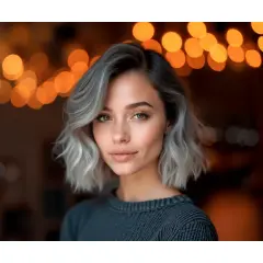 Mujer con pelo corto rubio platino ceniza, mirada cautivadora y luces de bokeh cálidas de fondo.