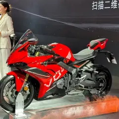 Presentación de la Voge 666 RR, una moto deportiva roja brillante, con una presentadora hablando al micrófono.