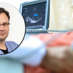 Lekarz w okularach przy aparacie USG, na ekranie widoczny obraz badania, które może pomóc wykryć raka piersi.