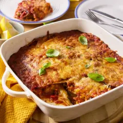 Pyszna parmigiana z bakłażana, zapieczona z sosem pomidorowym i serem, udekorowana listkami bazylii.