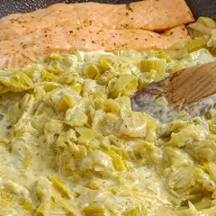 Saumon poêlé avec une sauce crémeuse aux poireaux. Une recette simple et savoureuse pour un dîner rapide.
