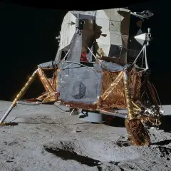 Moduł księżycowy z misji **projekt Apollo** osadzony na szarym gruncie Księżyca.