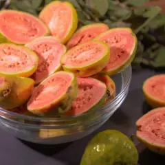 Kusząca guawa jak jeść? Pokrojone owoce w misce i na blacie, gotowe do degustacji.