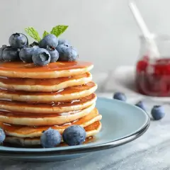 Pyszny stosik naleśników z syropem, borówkami i miętą. Idealny przepis na pancake na słodkie śniadanie.
