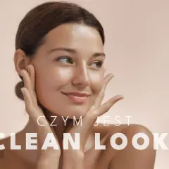 Uśmiechnięta kobieta z promienną cerą, uosabiająca clean girl aesthetic. Delikatny dotyk dłoni podkreśla naturalne piękno.