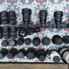 Kolekcja aparatów i obiektywów, w tym teleobiektyw. Zastanawiasz się, teleobiektyw co to? To obiektyw o długiej ogniskowej, idealny do fotografowania odległych obiektów.