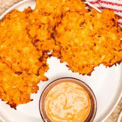 Knusprige Kartoffelpuffer, im Ofen gebacken, serviert mit einer cremigen Dip-Sauce. Perfekt für einen herzhaften Snack.