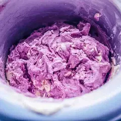 Frisch zubereitetes, lila gefrorenes Joghurt-Rezept in einer Eismaschine.