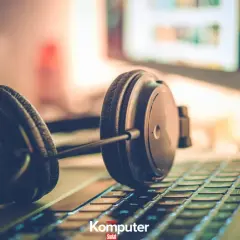 Słuchawki na klawiaturze laptopa, gotowe do zanurzenia się w muzyce na komputerze.