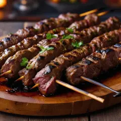 Soczyste, grillowane szaszłyki mięsne na drewnianej desce. Tak wygląda kebab w Turcji – aromatyczny, z przypieczonymi paskami i świeżą natką pietruszki.