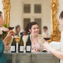 Trois femmes profitent d'une dégustation de vin au Château de Pommard, admirant le contenu de leurs verres.