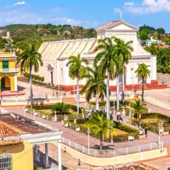 Plaza de Trinidad, Cuba. Un lugar perfecto para planear cuando viajar a Cuba, con su iglesia blanca, casas coloniales y palmeras.