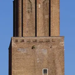 La torre delle Milizie, imponente struttura in mattoni, si staglia contro un cielo azzurro.