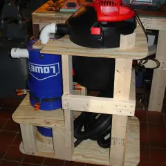 Aspirateur copeaux Leman ASP152 sur un support en bois avec un seau bleu Lowe's.