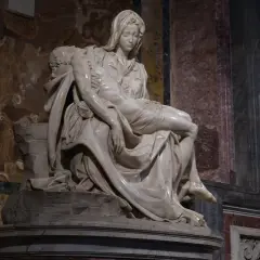 Pieta Michała Anioła: Matka Boska tuli martwe ciało Jezusa. Marmurowa rzeźba pełna bólu i piękna.