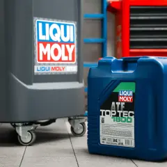 Niebieski kanister z olejem Liqui Moly ATF Top Tec 1800 w warsztacie. Zastanawiasz się, ile bierze mechanik za wymianę oleju?